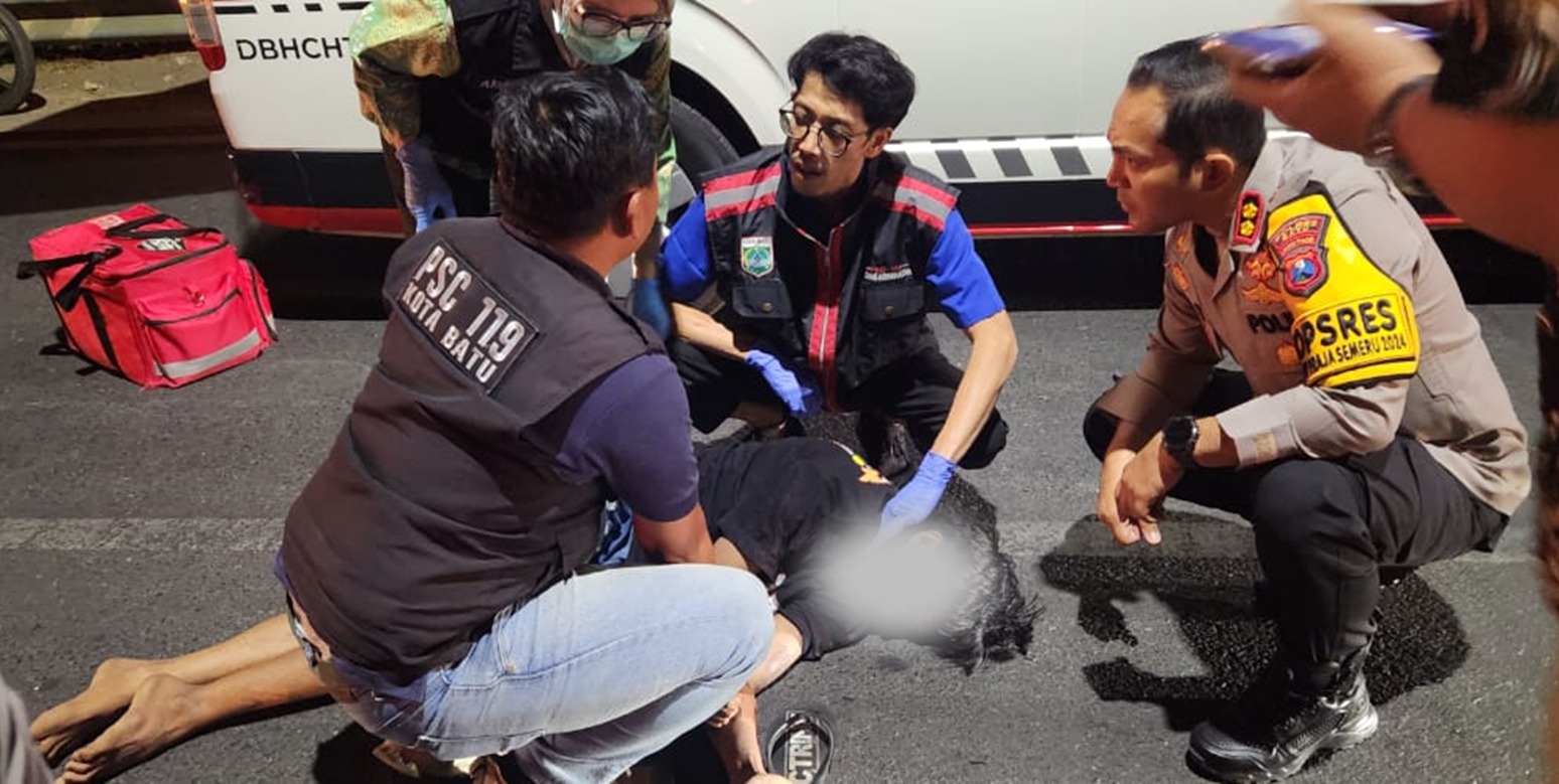 Kapolres Batu AKBP Andi Yudha Pranata membantu evakuasi korban tabrak lari di Jalan Raya Pandanrejo. Kamis (19/9/2024) malam.